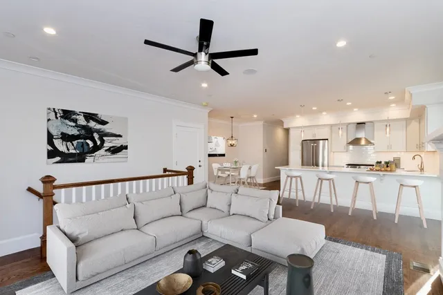 a living room with furniture and a view of kitchen