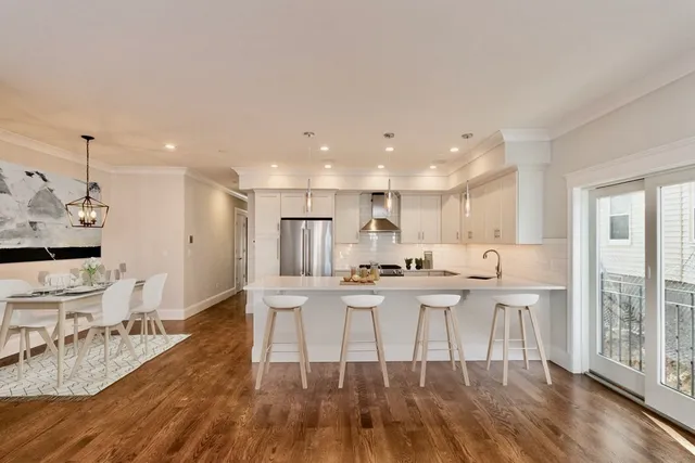 a kitchen with stainless steel appliances kitchen island granite countertop a table and chairs in it