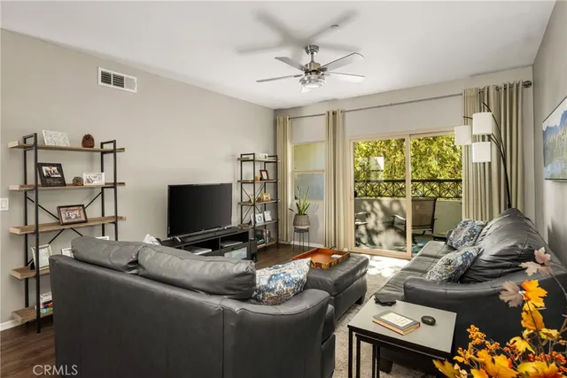 a kitchen with granite countertop a dining table chairs refrigerator and wooden floor