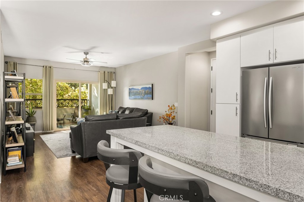 425 South Anaheim Boulevard, Unit 3 Anaheim, CA 92805 - Photo 23 of 53 a kitchen with granite countertop a dining table chairs refrigerator and wooden floor