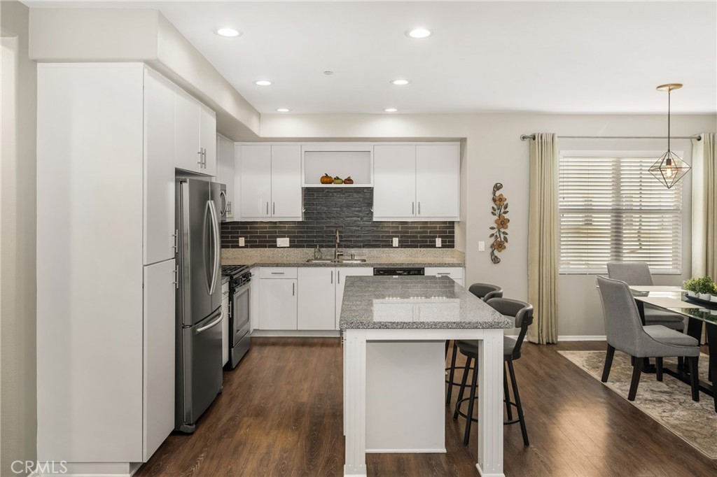 425 South Anaheim Boulevard, Unit 3 Anaheim, CA 92805 - Photo 29 of 53 a kitchen with stainless steel appliances granite countertop a refrigerator stove microwave and a dining table with wooden floor