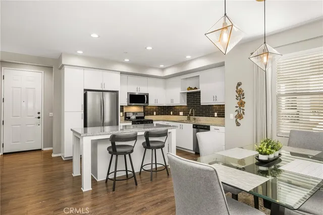 a living room with furniture kitchen view and a refrigerator