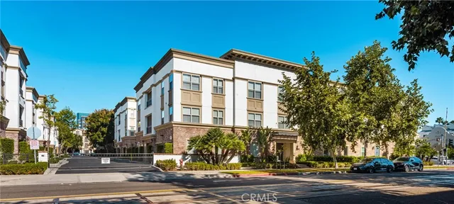 a view of a house with potted plants and a fountain