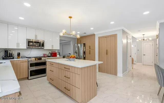 a kitchen with kitchen island granite countertop a sink counter top space appliances and cabinets