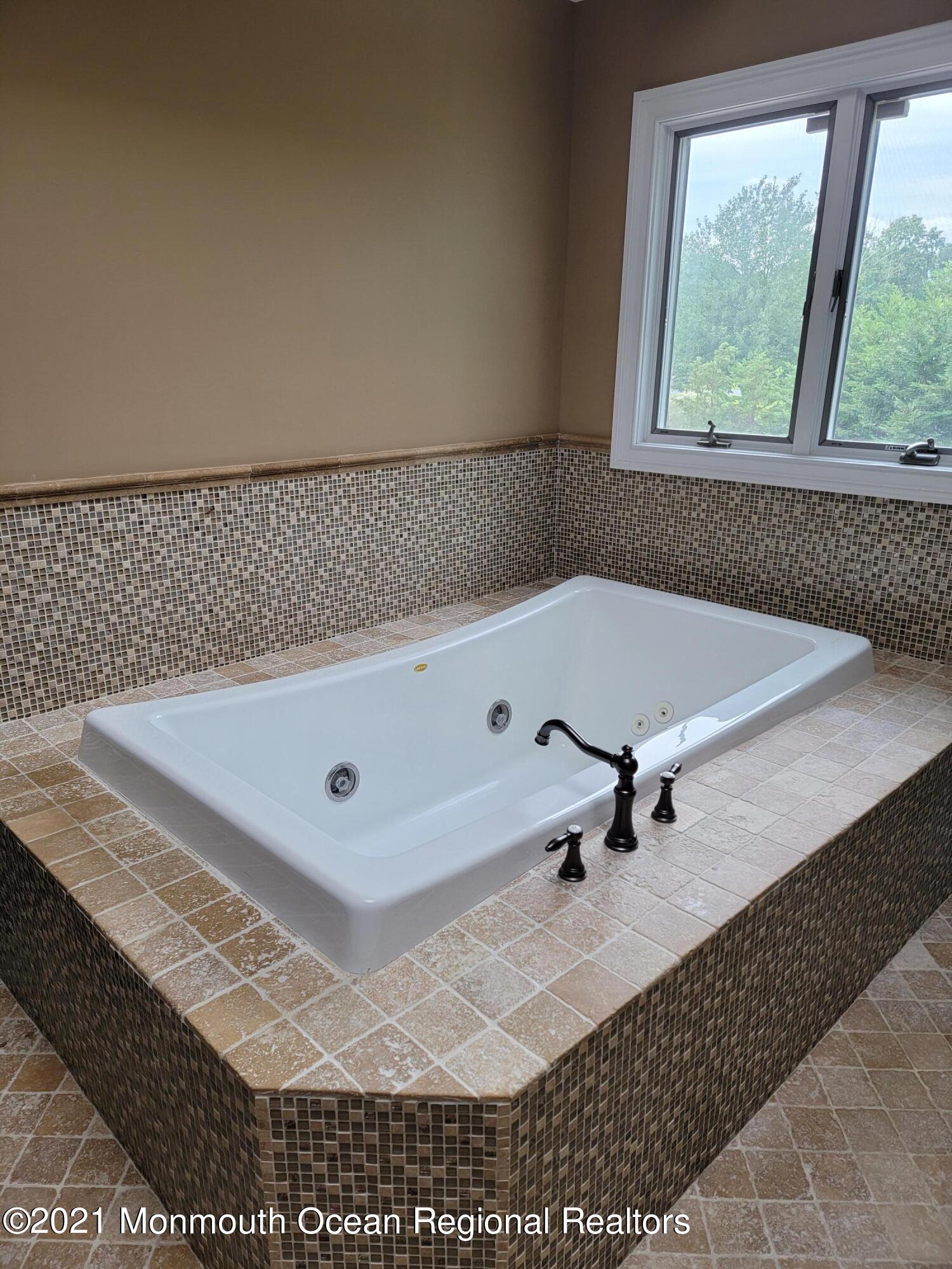 28 Musket Lane Eatontown, NJ 07724 - Photo 13 of 26 a bathroom with a bathtub and window