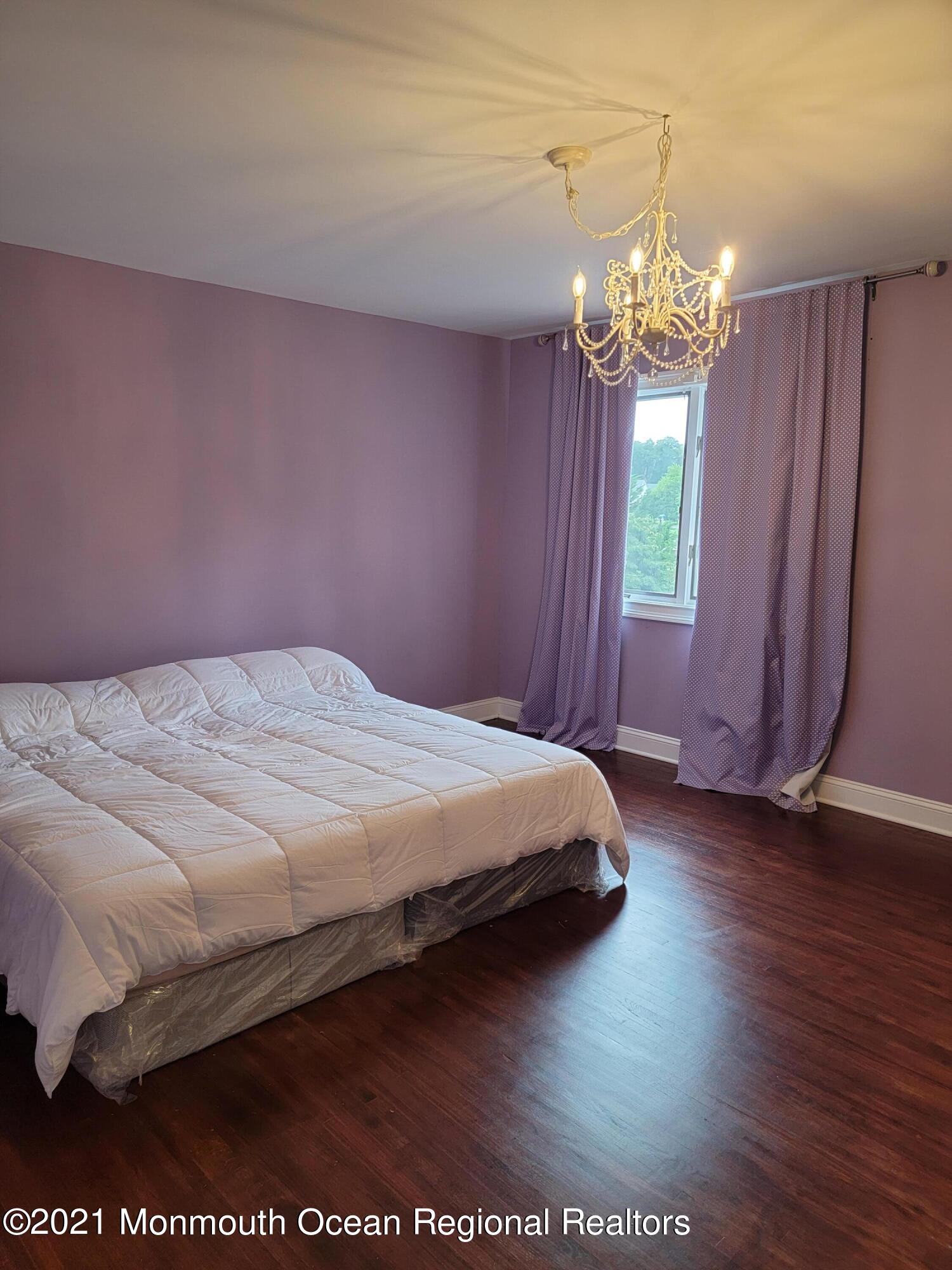 28 Musket Lane Eatontown, NJ 07724 - Photo 14 of 26 a bedroom with a bed and a chandelier