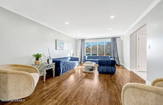 a living room with furniture and a wooden floor