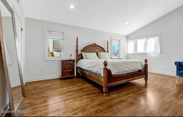 a bedroom with a bed lamp and a window