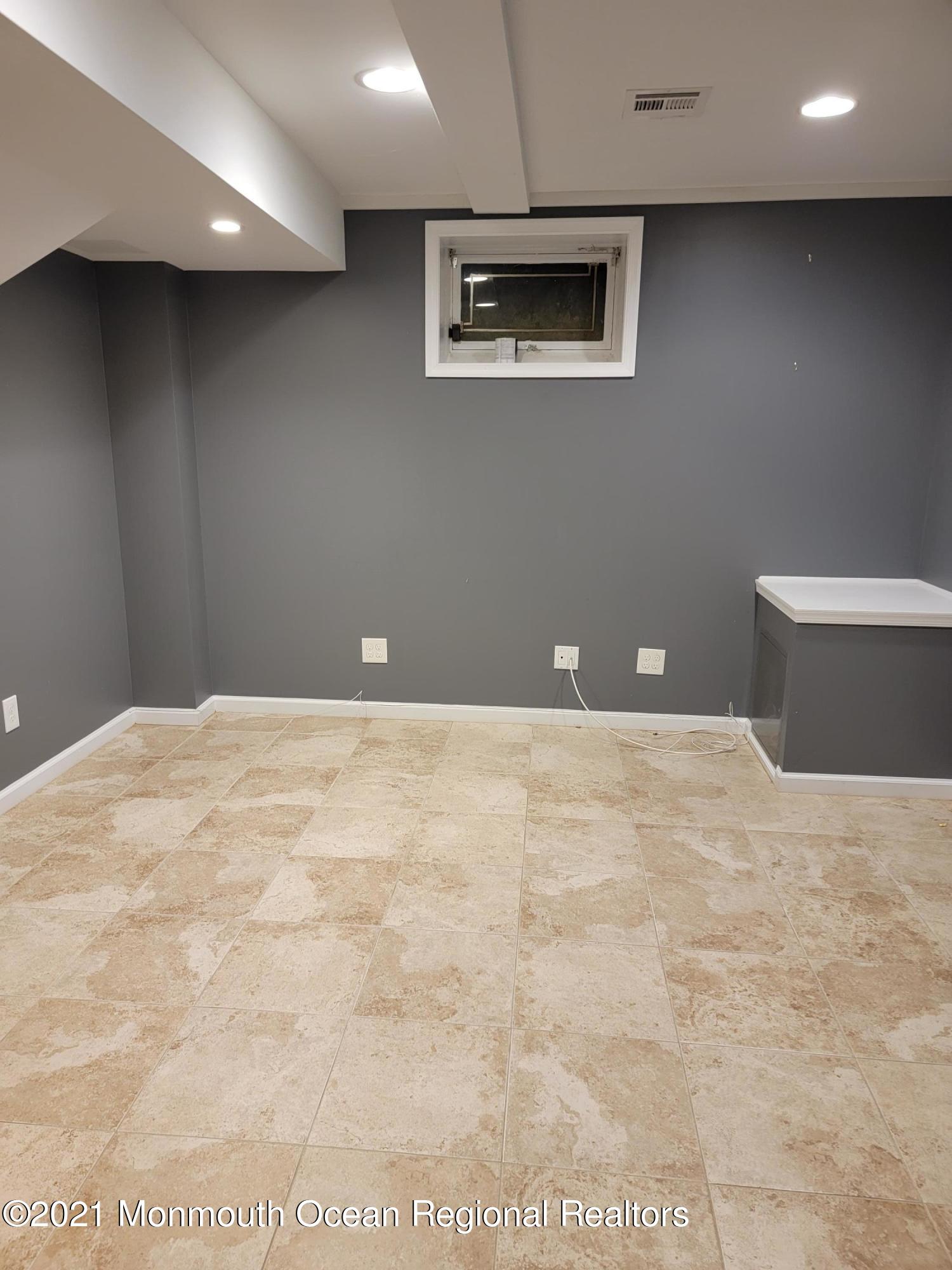 28 Musket Lane Eatontown, NJ 07724 - Photo 21 of 26 a view of a livingroom with an empty space and a projector