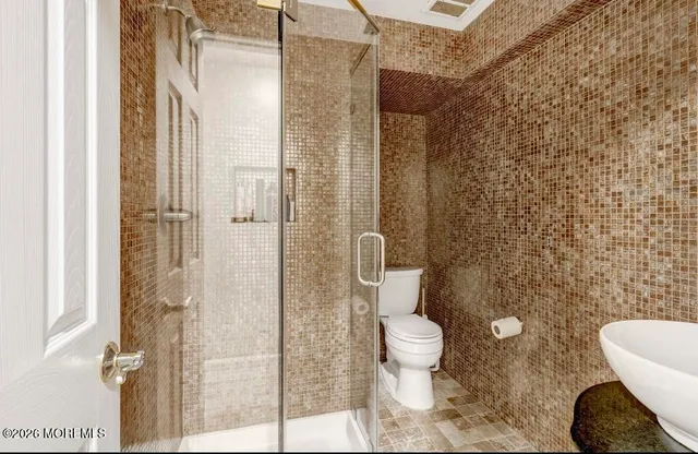 a bathroom with a toilet and a shower