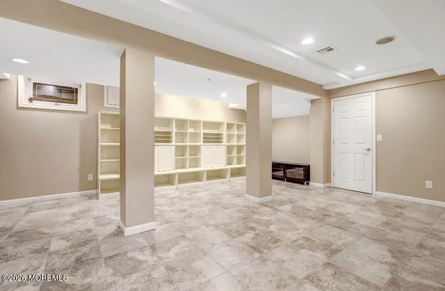 a view of an empty room with a fireplace and workspace