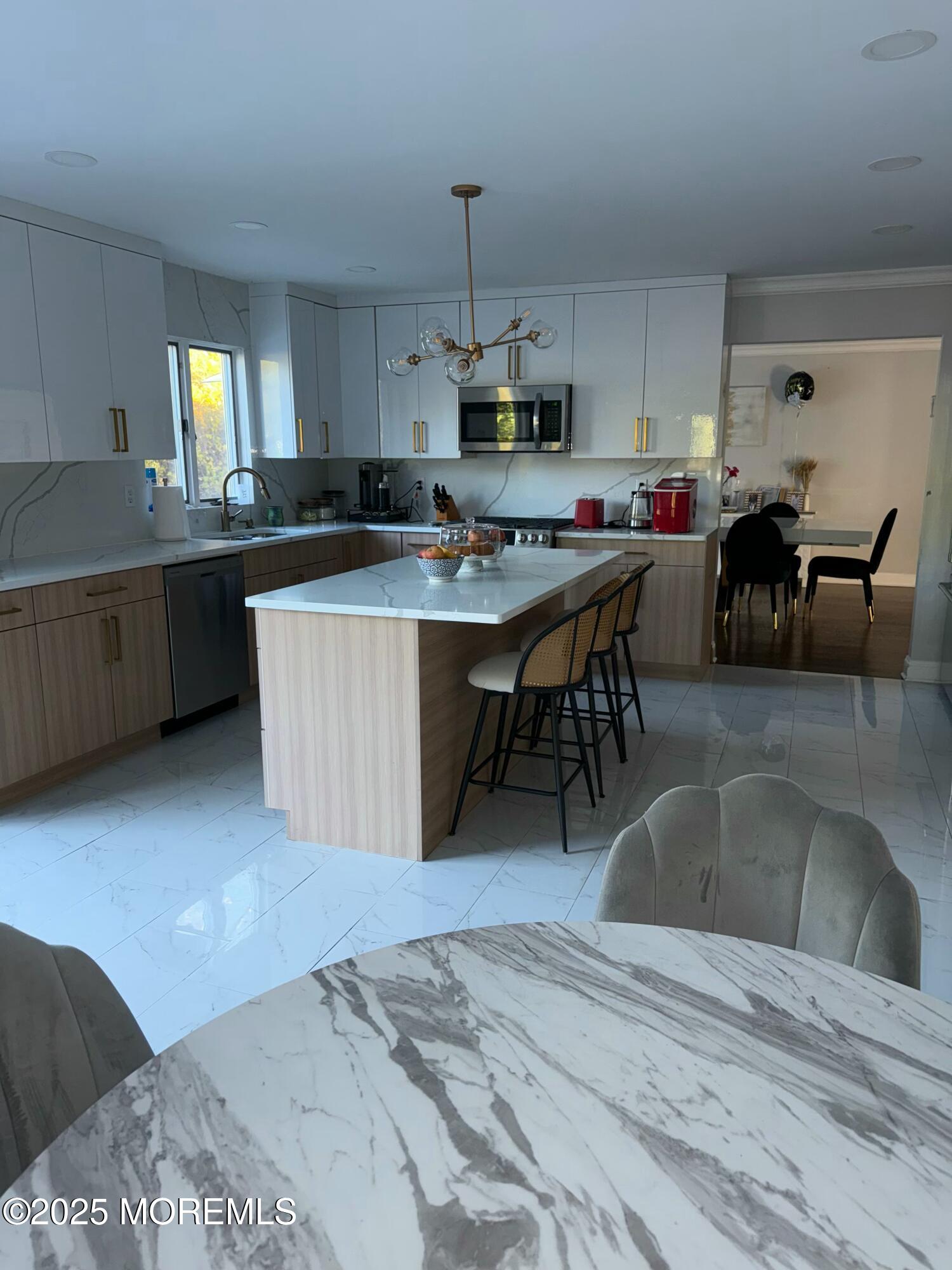 28 Musket Lane Eatontown, NJ 07724 - Photo 10 of 26 a kitchen with kitchen island granite countertop a sink dining table and chairs