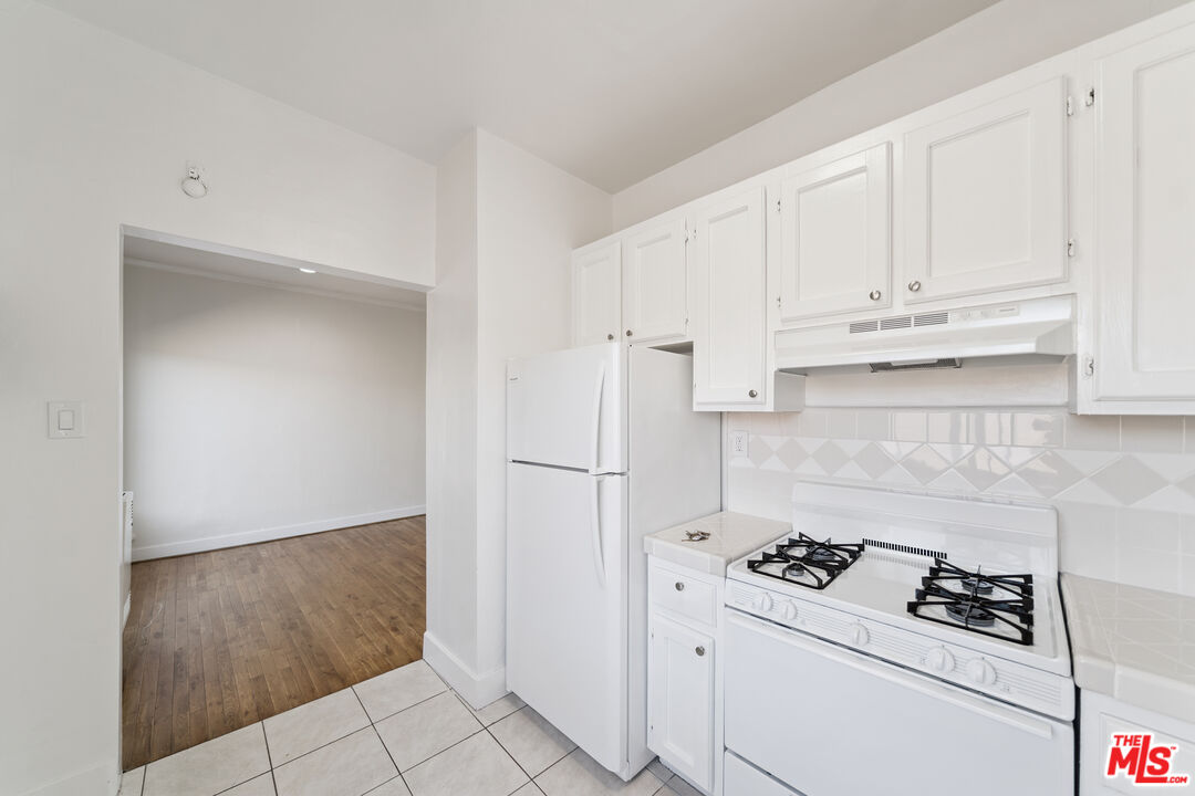 1267 Vin Scully Avenue, Unit 24 Los Angeles, CA 90026 - Photo 4 of 9 a kitchen with white cabinets and white appliances