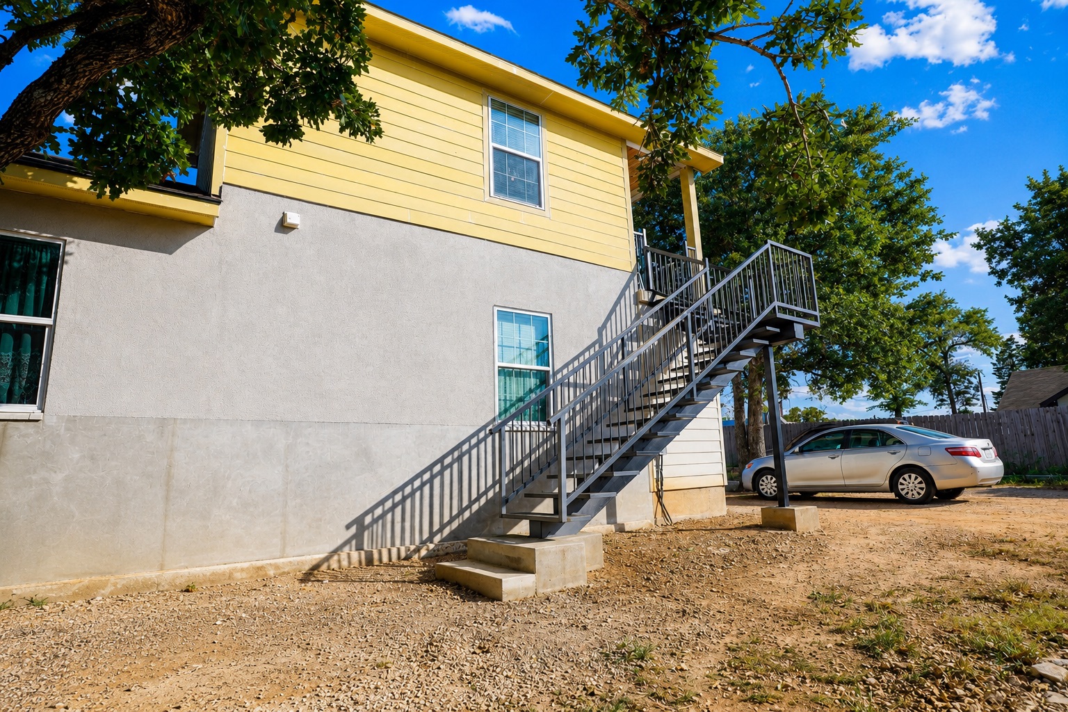 158 Buena Fortuna Road Elgin, TX 78621 - Photo 26 of 40 A well-maintained multi-level building offers private external stairs and a practical ground-level access.