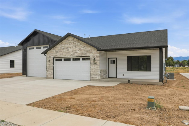 164 North 400 East Preston, ID 83263 - Photo 20 of 21 Modern farmhouse exterior featuring light-colored stone accents, white siding, and dark trim