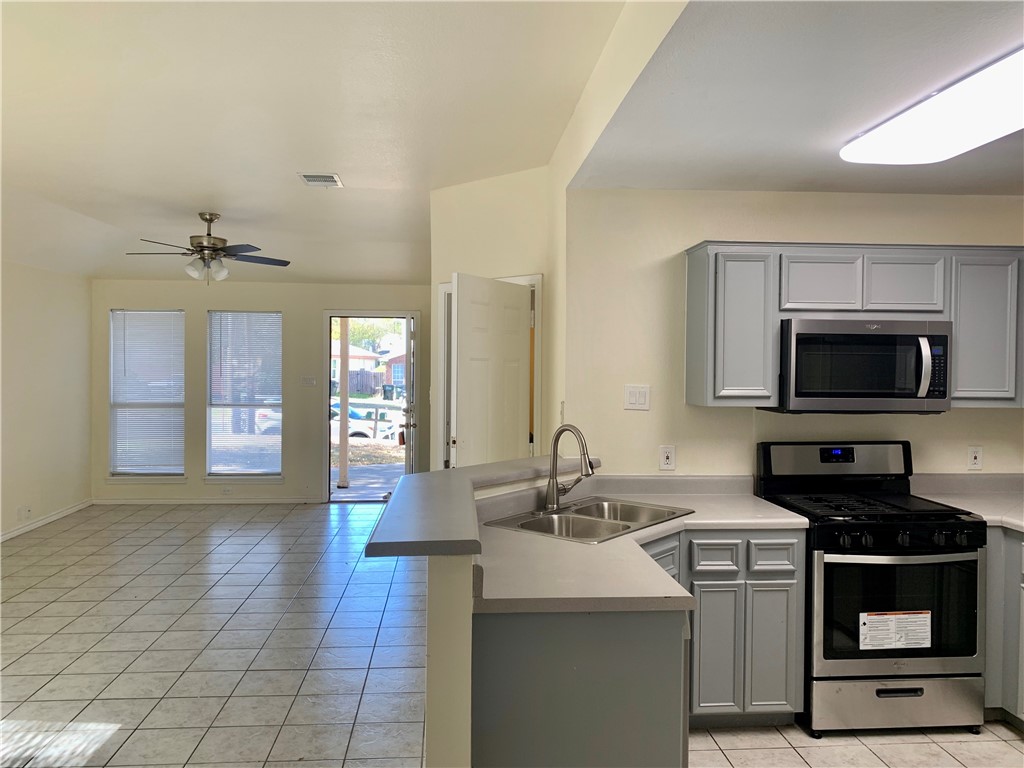a kitchen with stainless steel appliances a sink stove and microwave