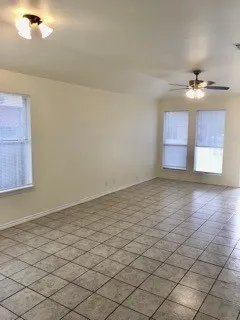 an empty room with windows and fan