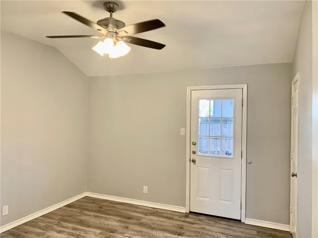 an empty room with windows and fan