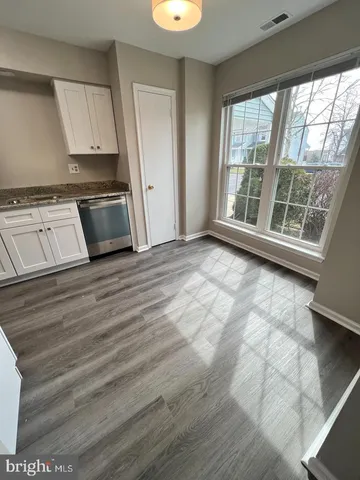 a view of a kitchen with wooden floor and electronic appliances