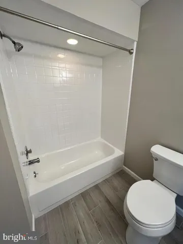 a white toilet sitting next to a bath tub