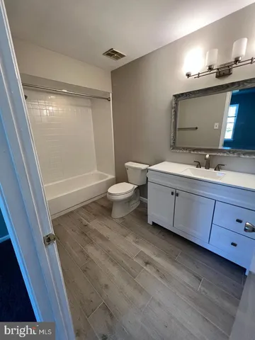 a bathroom with a double vanity sink mirror and toilet