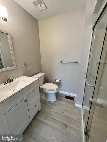 a bathroom with a granite countertop sink toilet and a mirror