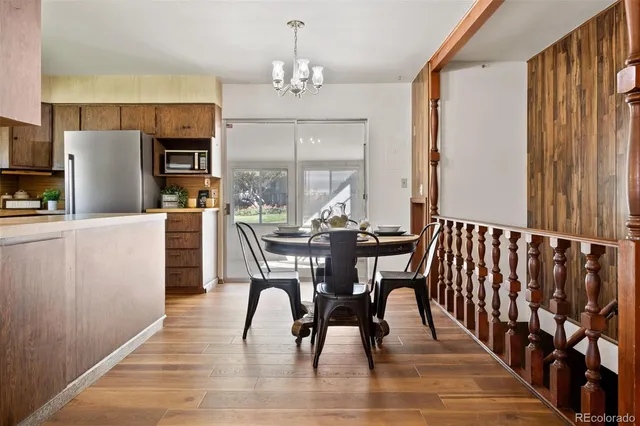 a dining room with furniture a chandelier and wooden floor