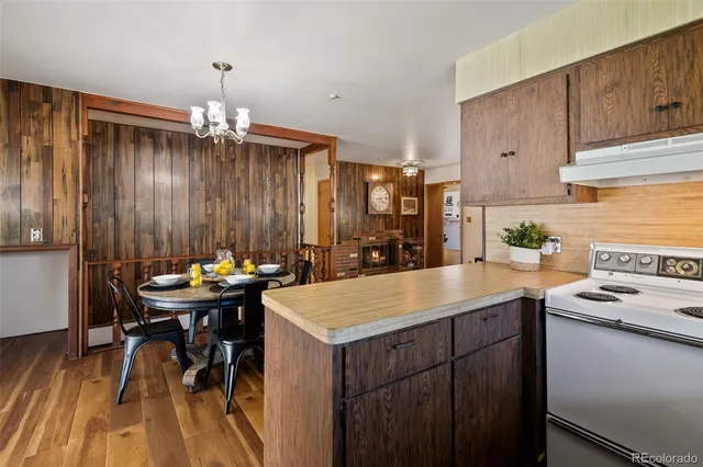 a kitchen with a sink appliances and wooden floor