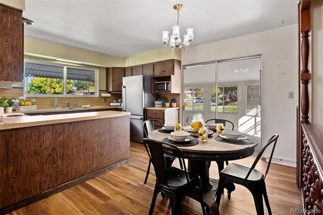 a dining room with furniture a kitchen and a chandelier
