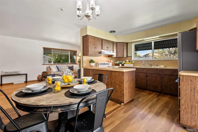 a kitchen with a dining table chairs and stove