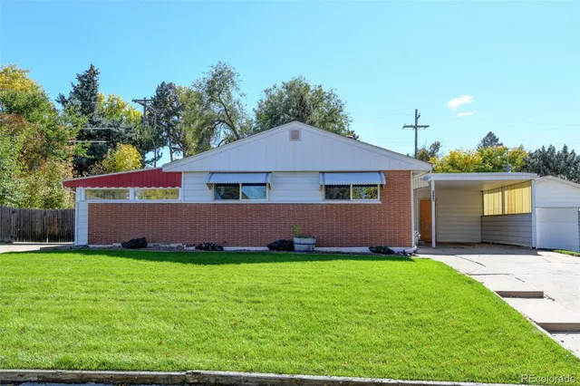 a front view of house with yard and trees in the background