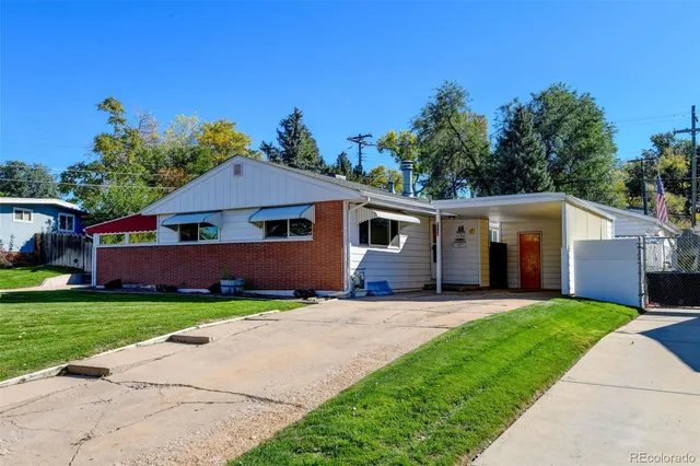 a front view of a house with a yard and trees