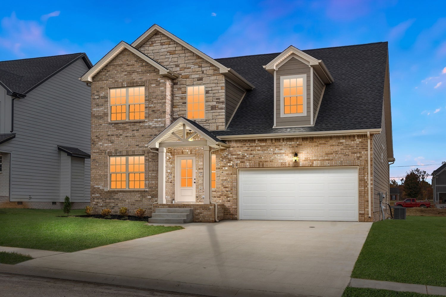 a front view of a house with a garden and garage