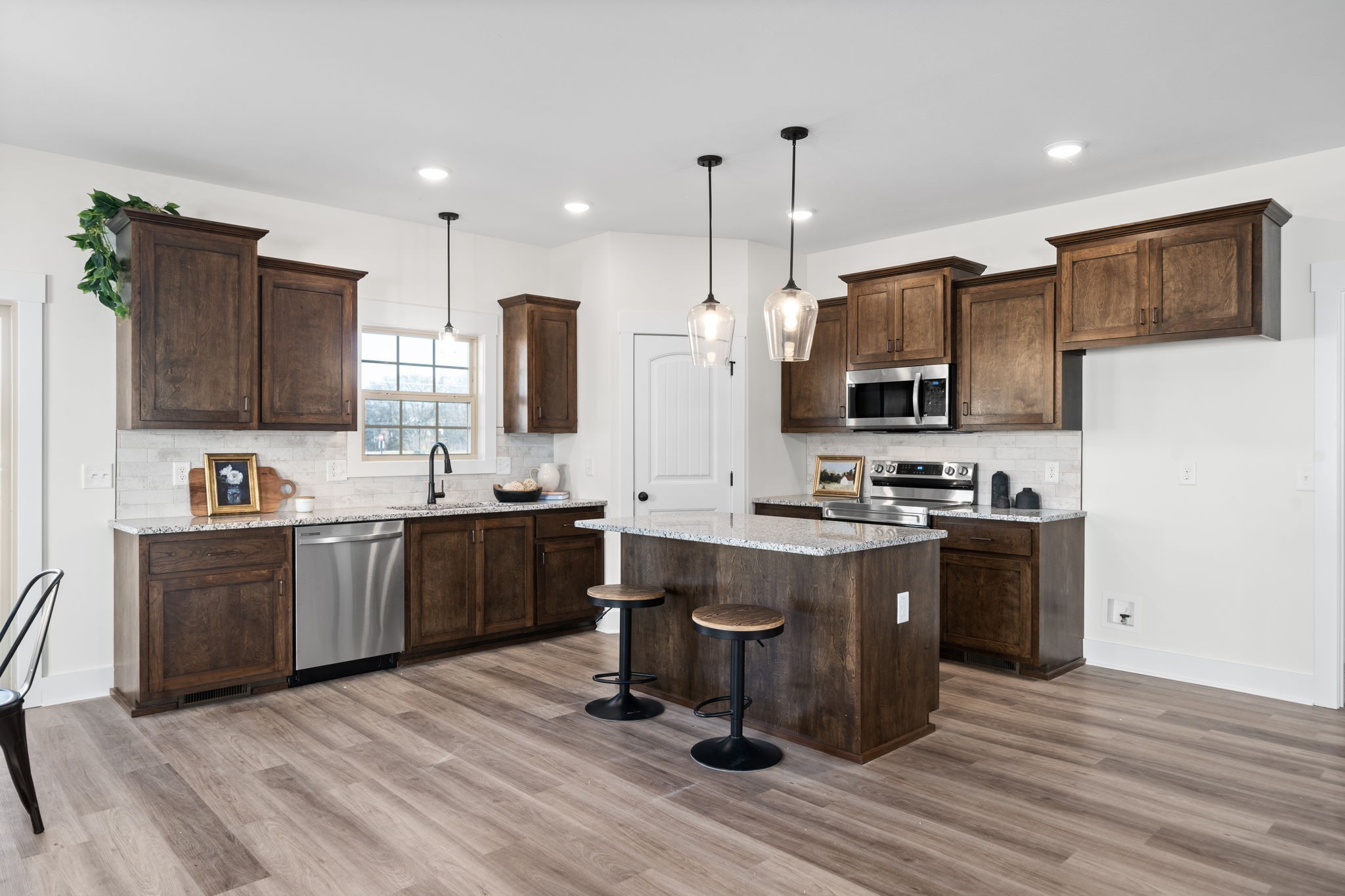 189 Dewberry Road Clarksville, TN 37042 - Photo 19 of 52 a view of kitchen with stainless steel appliances granite countertop a stove top oven a sink dishwasher a refrigerator and a dining table with wooden floor