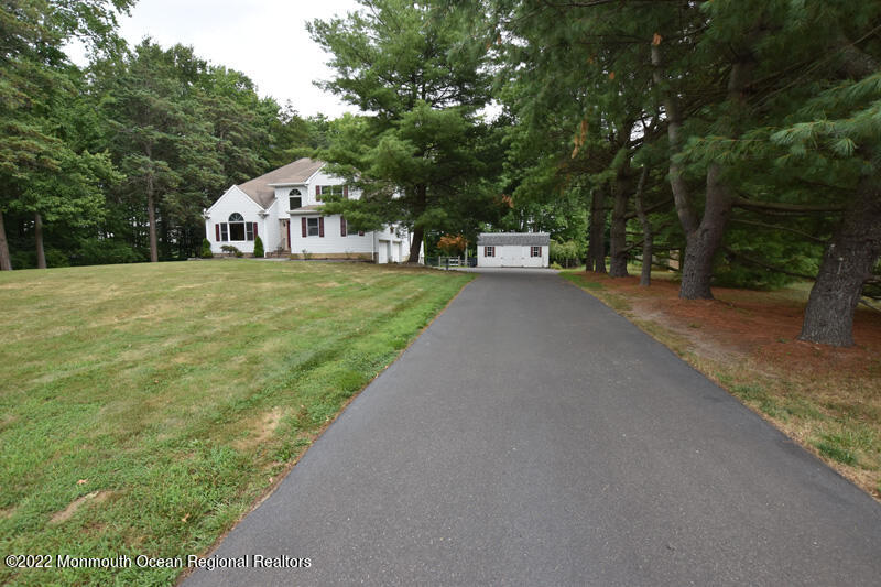 84 Daum Road Manalapan, NJ 07726 - Photo 45 of 50 a front view of a house with a yard and trees