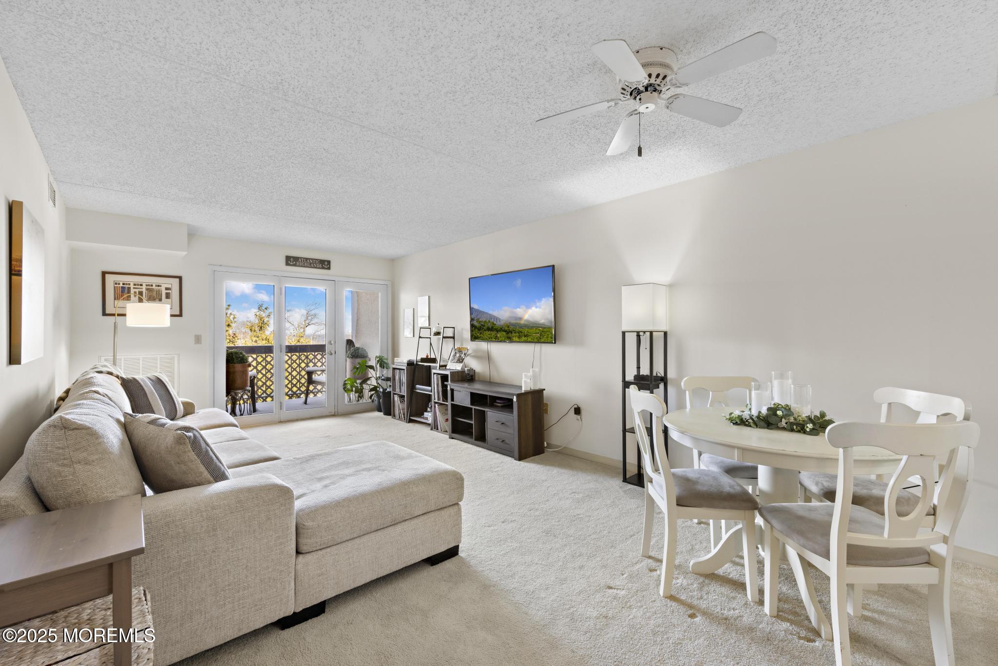 a living room with furniture a flat screen tv and kitchen view