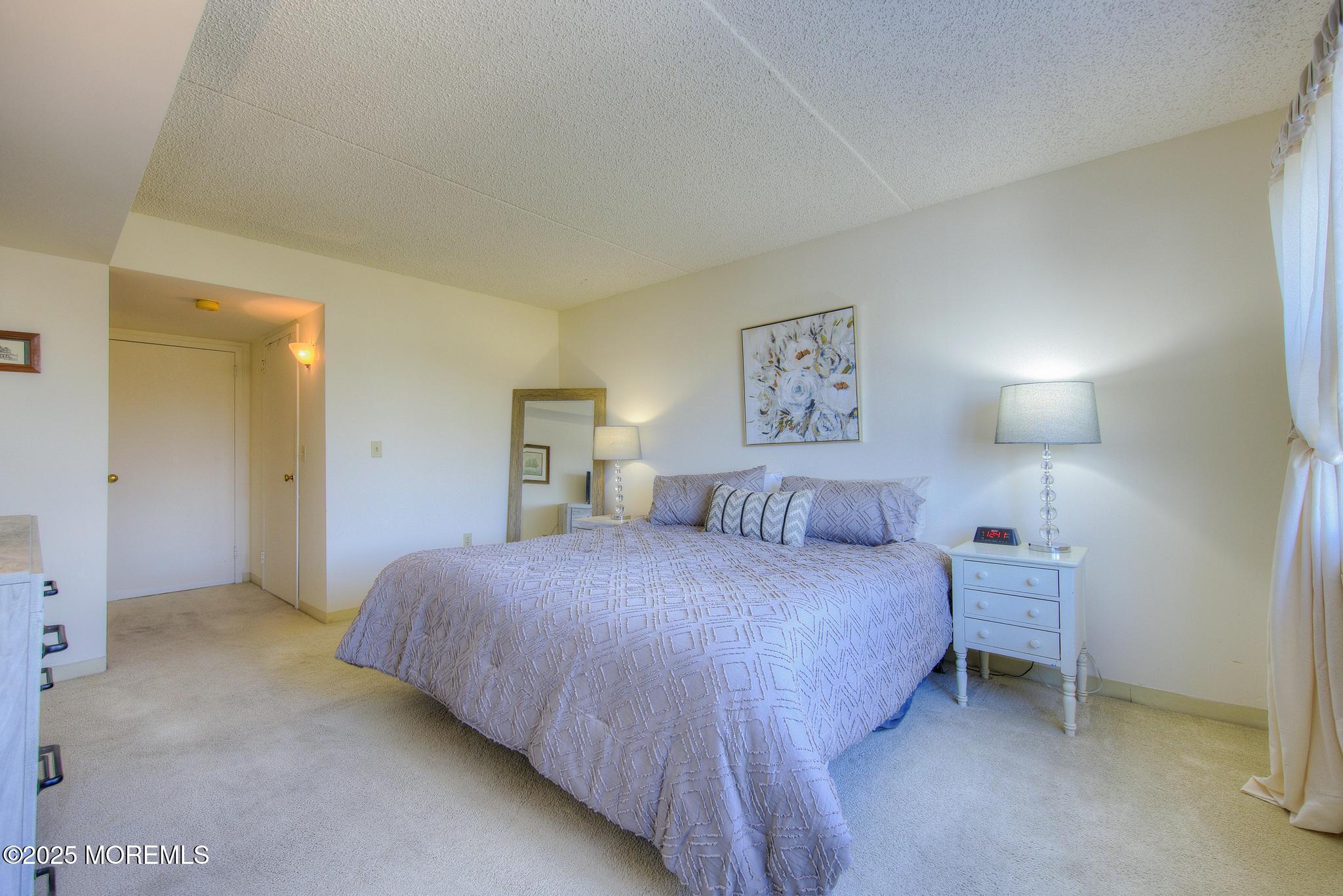 32 Center Avenue, Unit 17 Atlantic Highlands, NJ 07716 - Photo 14 of 27 a bedroom with a bed and a lamp on dresser