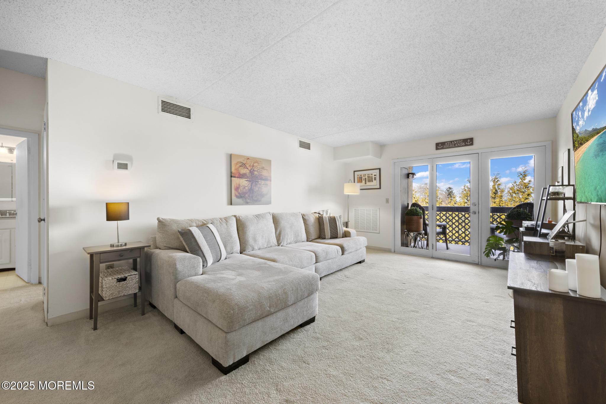 32 Center Avenue, Unit 17 Atlantic Highlands, NJ 07716 - Photo 2 of 27 a living room with furniture and a table
