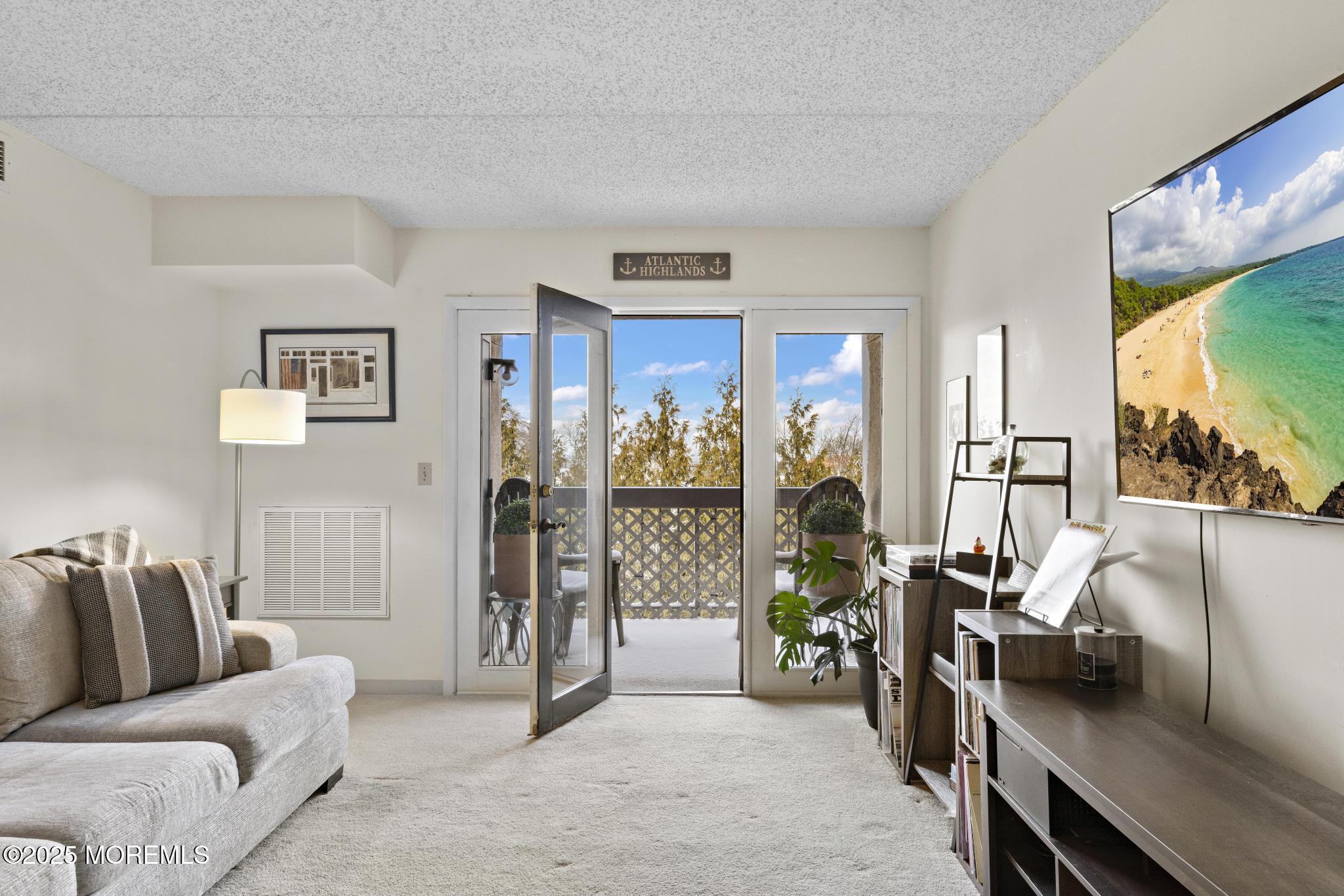 32 Center Avenue, Unit 17 Atlantic Highlands, NJ 07716 - Photo 3 of 27 a living room with furniture and a flat screen tv