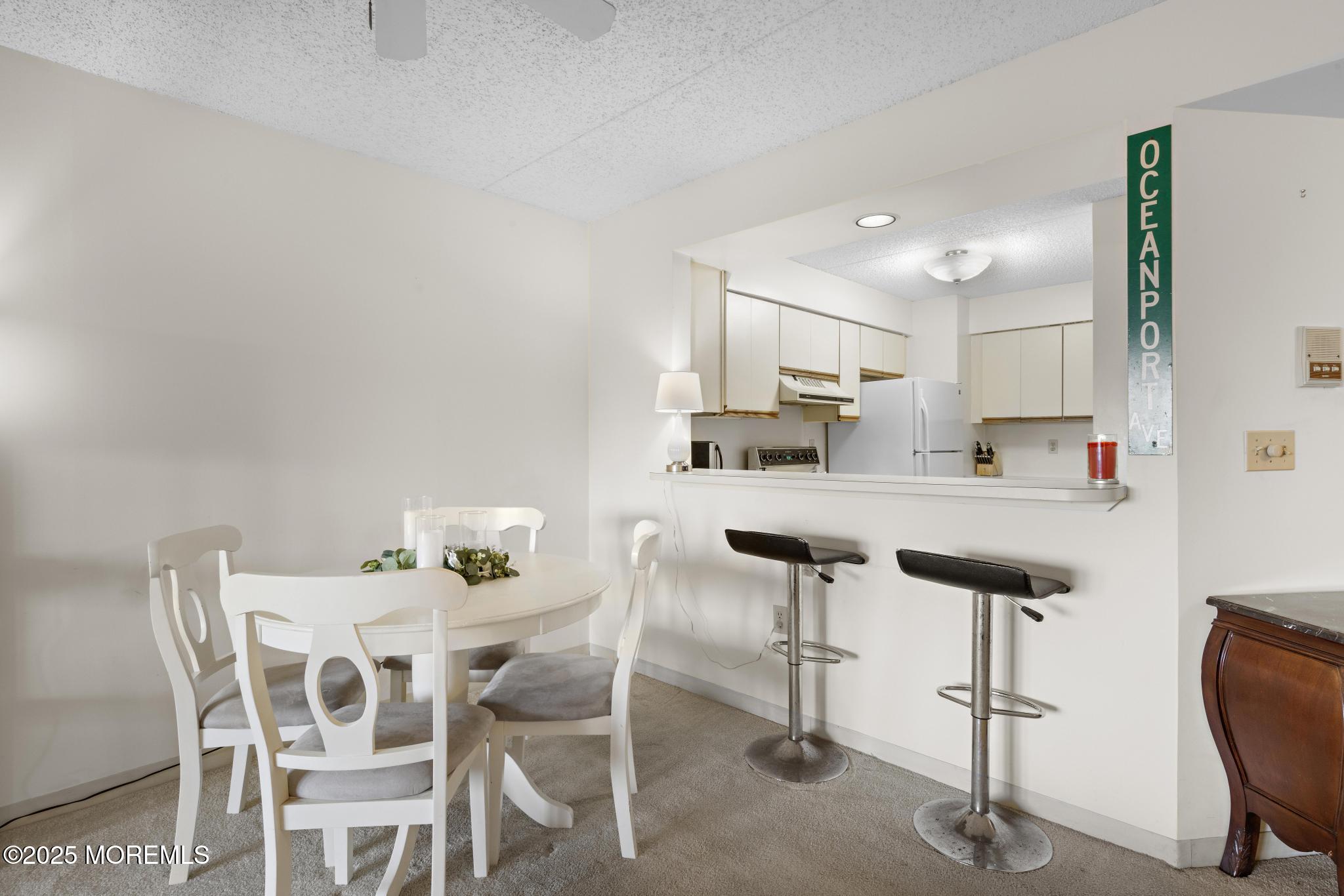 32 Center Avenue, Unit 17 Atlantic Highlands, NJ 07716 - Photo 7 of 27 a kitchen with kitchen island cabinets and chairs in it