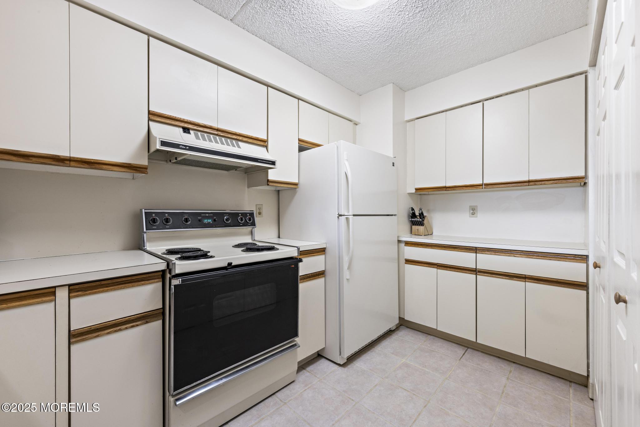 32 Center Avenue, Unit 17 Atlantic Highlands, NJ 07716 - Photo 9 of 27 a kitchen with cabinets and a stove top oven