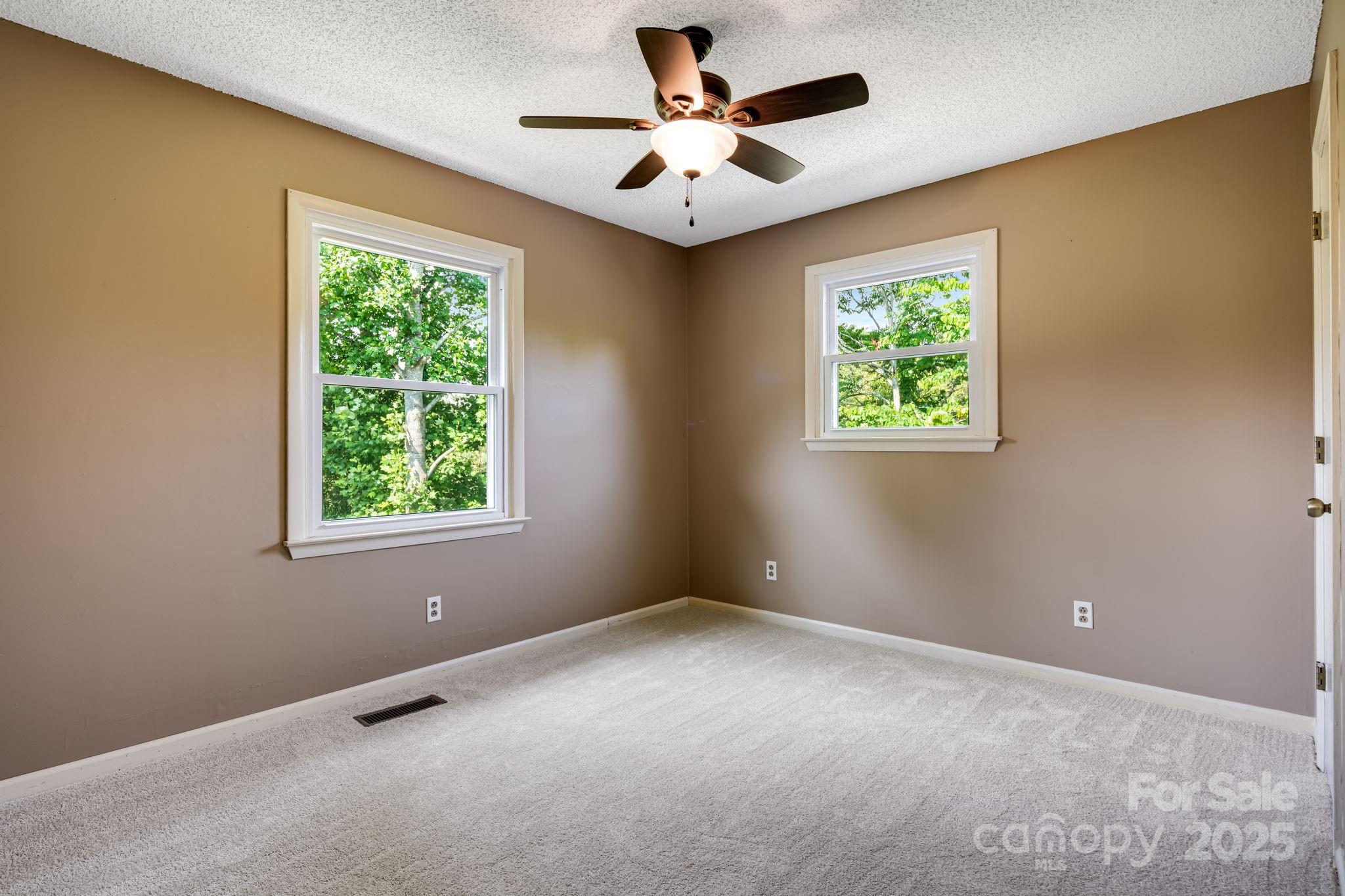 1360 Jupiter Road Weaverville, NC 28787 - Photo 15 of 39 an empty room with windows and ceiling fan