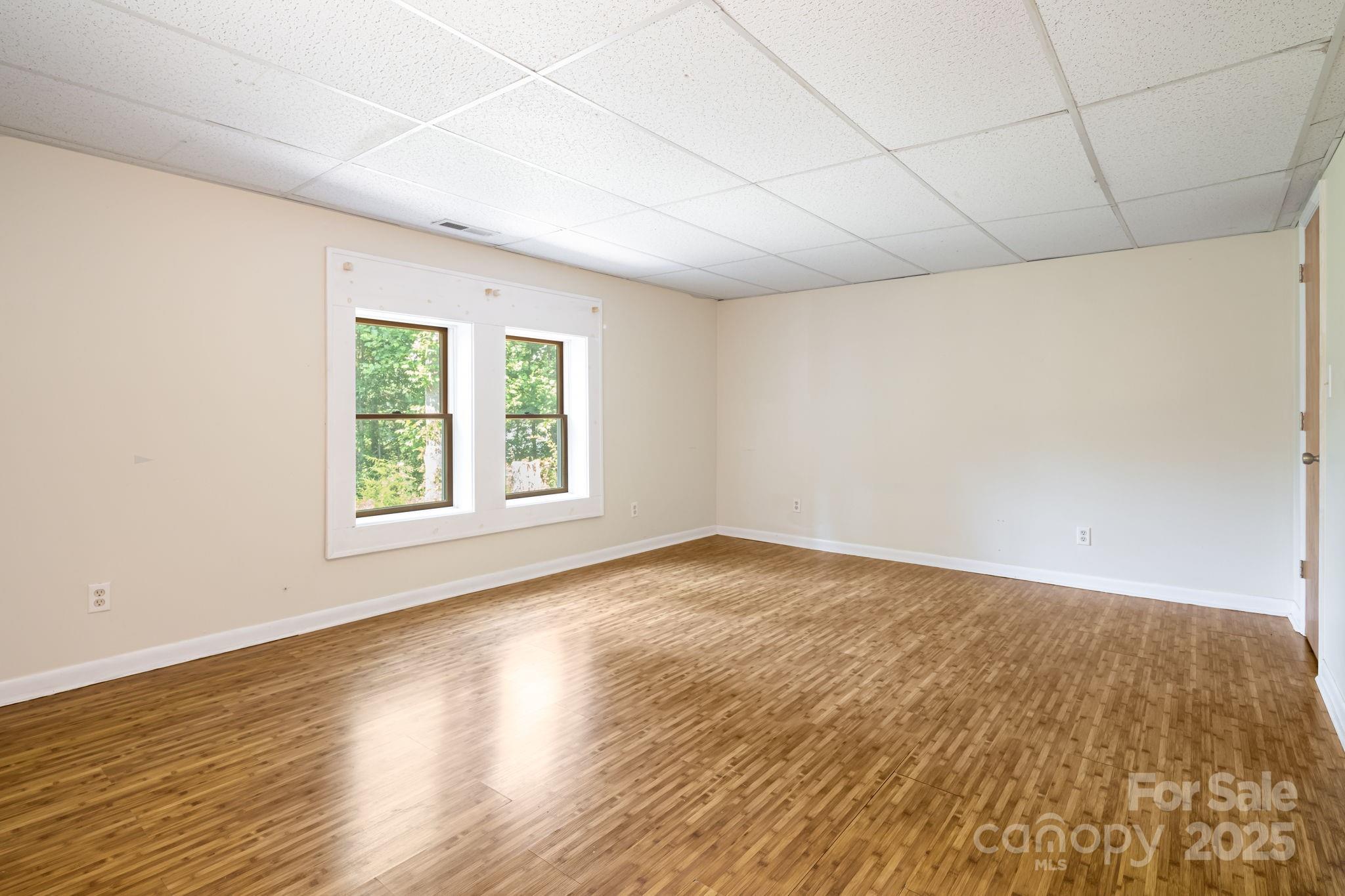 1360 Jupiter Road Weaverville, NC 28787 - Photo 23 of 39 an empty room with wooden floor and windows