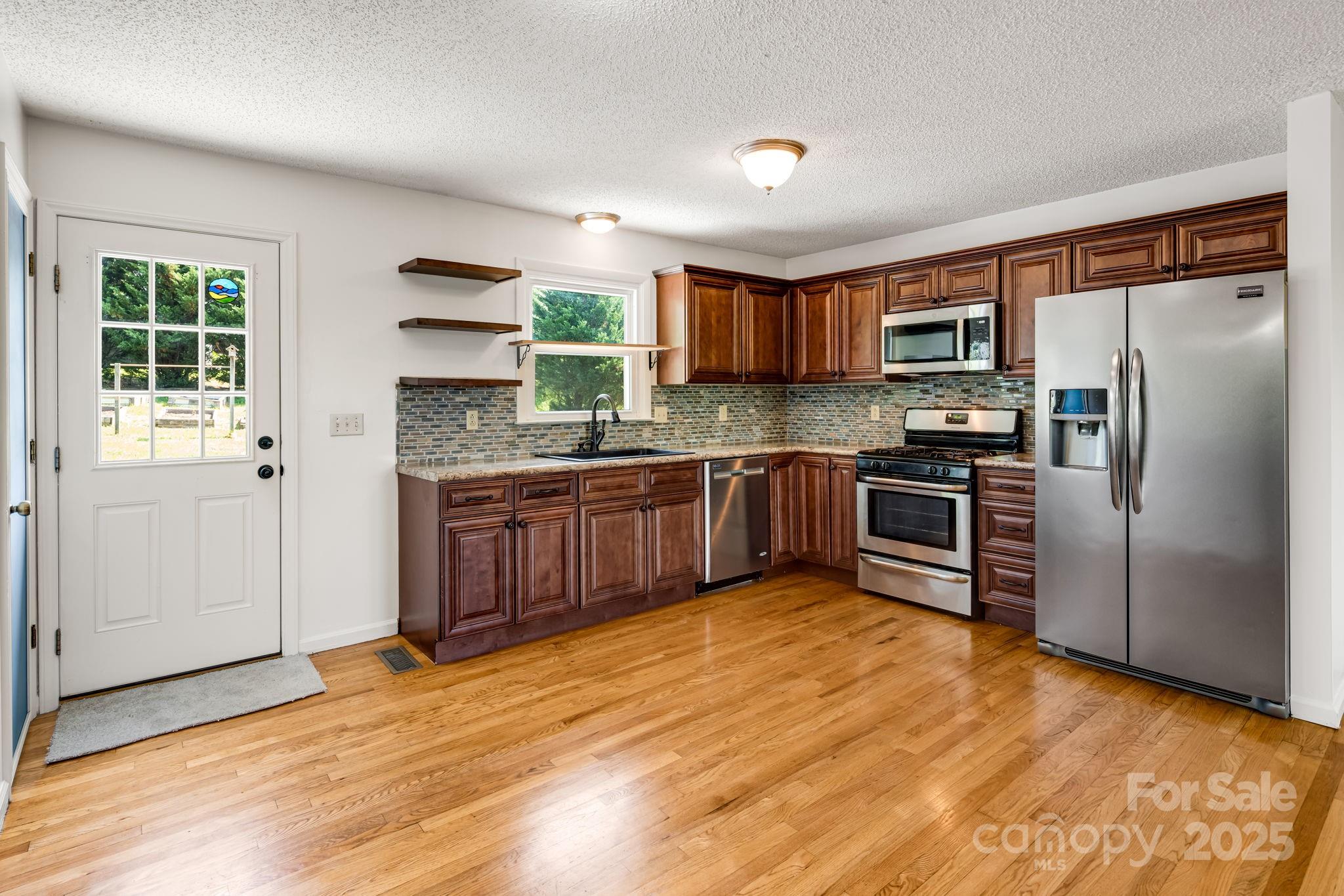 1360 Jupiter Road Weaverville, NC 28787 - Photo 7 of 39 a kitchen with stainless steel appliances granite countertop a stove top oven a sink and a refrigerator