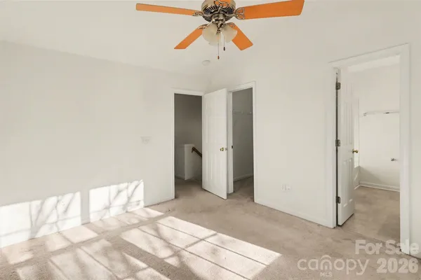 a view of a room with a chandelier fan and closet