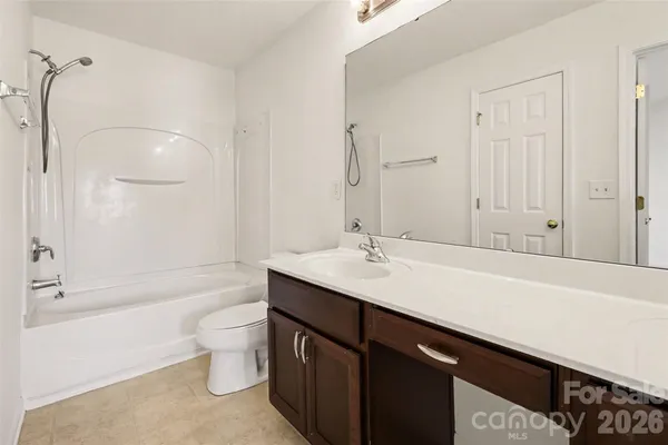 a bathroom with a bathtub shower sink vanity and toilet