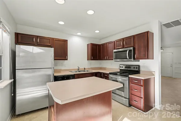 a kitchen with a refrigerator a stove top oven a sink and dishwasher