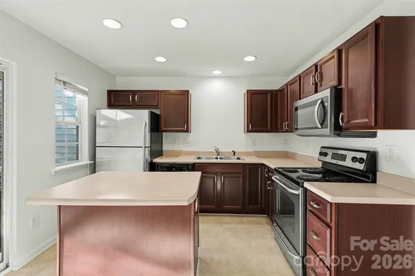 a kitchen with stainless steel appliances granite countertop a refrigerator stove a sink and a microwave