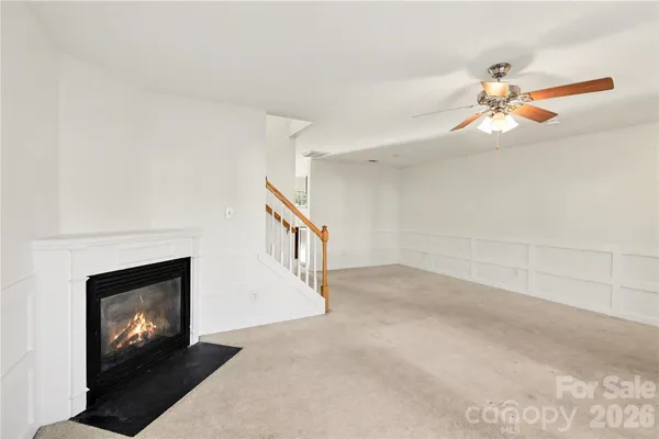 a view of an empty room with window and fireplace