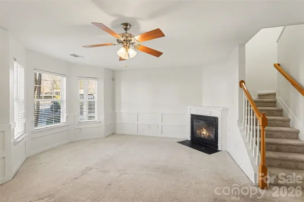 a view of an empty room with a fireplace and a window